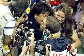 MEDAL NO. 8: Michael Phelps gets a kiss from his mother after winning his final gold medal.