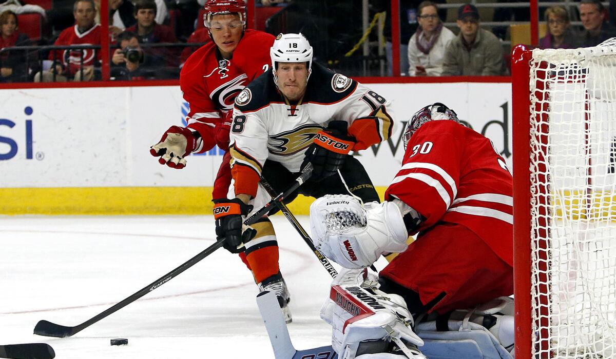 Ducks right wing Tim Jackman (18) skates past Hurricanes right wing Alexander Semin to take a shot against goalie Cam Ward in the first period Thursday night in Raleigh, N.C.