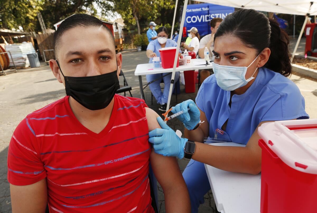 A nurse gives a man a COVID-19 shot.