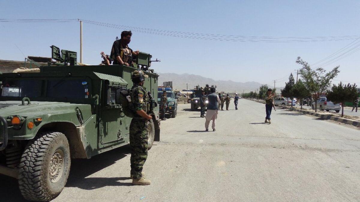 Security forces monitor a road near a mosque attacked by suicide bombers in Paktia, Afghanistan, on Friday.