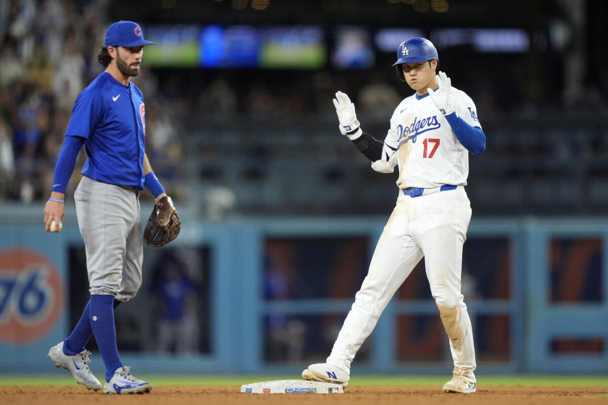 Shohei Ohtani puts his hands up in front of Chicago Cubs shortstop Dansby Swanson.