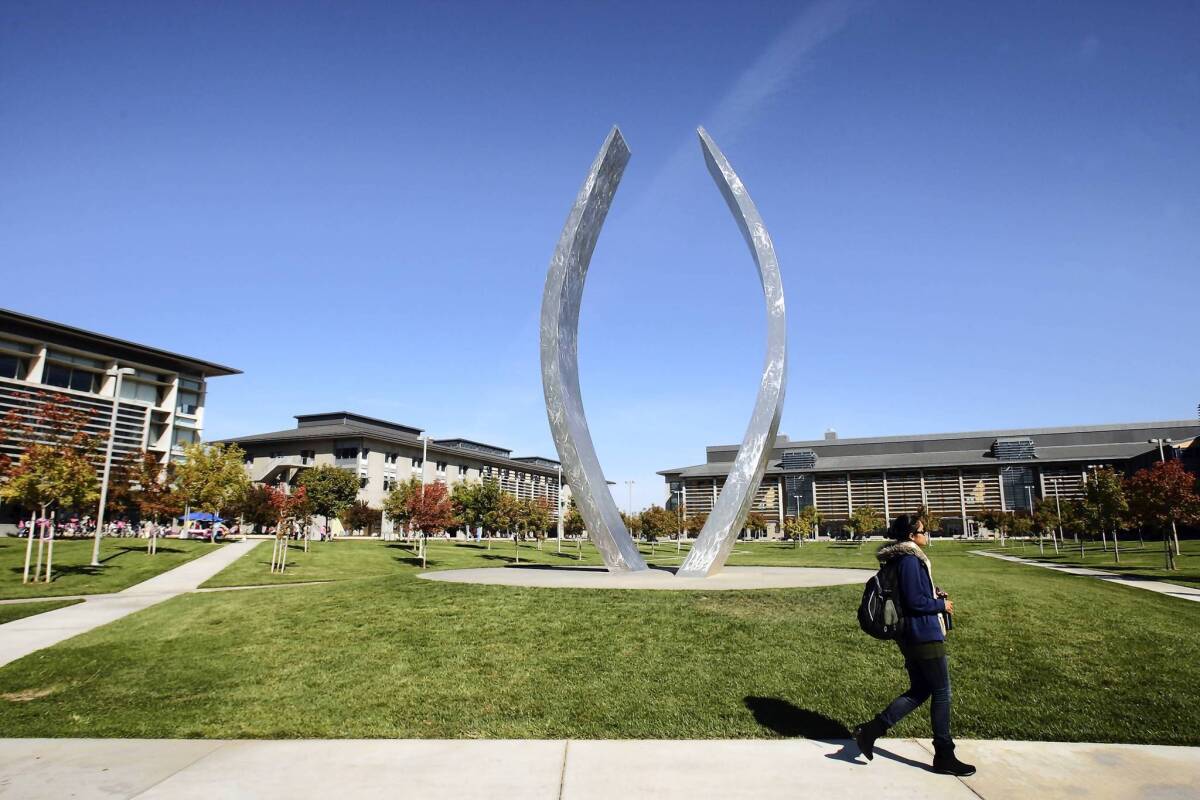 A student walks near a sculpture at UC Merced. The UC Regents have asked the state for $45 million to construct a lecture hall building that would increase overall classroom space by 50% and help boost enrollment from 5,700 students to 10,000.