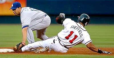 Atlanta Braves Gary Sheffield slides into second base late trying to stretch a single into a double as Dodgers second baseman Alex Cora makes the tag.