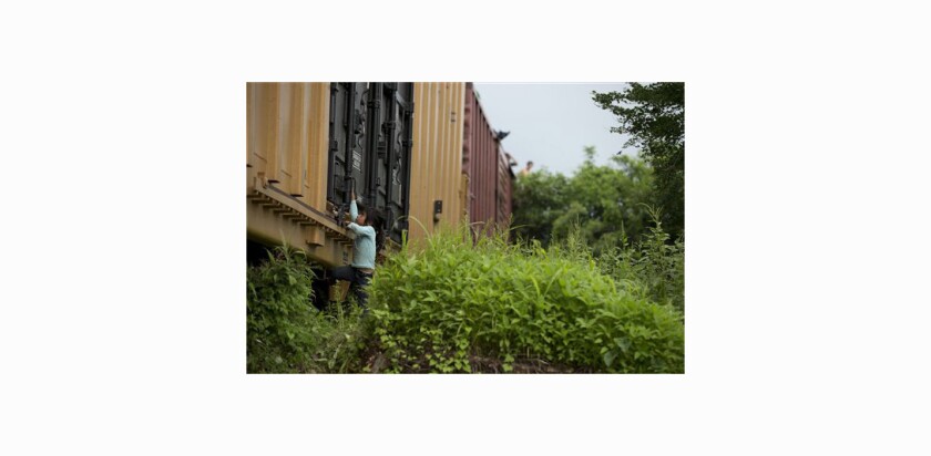 A girl traveling with Central American migrants plays on a freight train in southern Mexico.