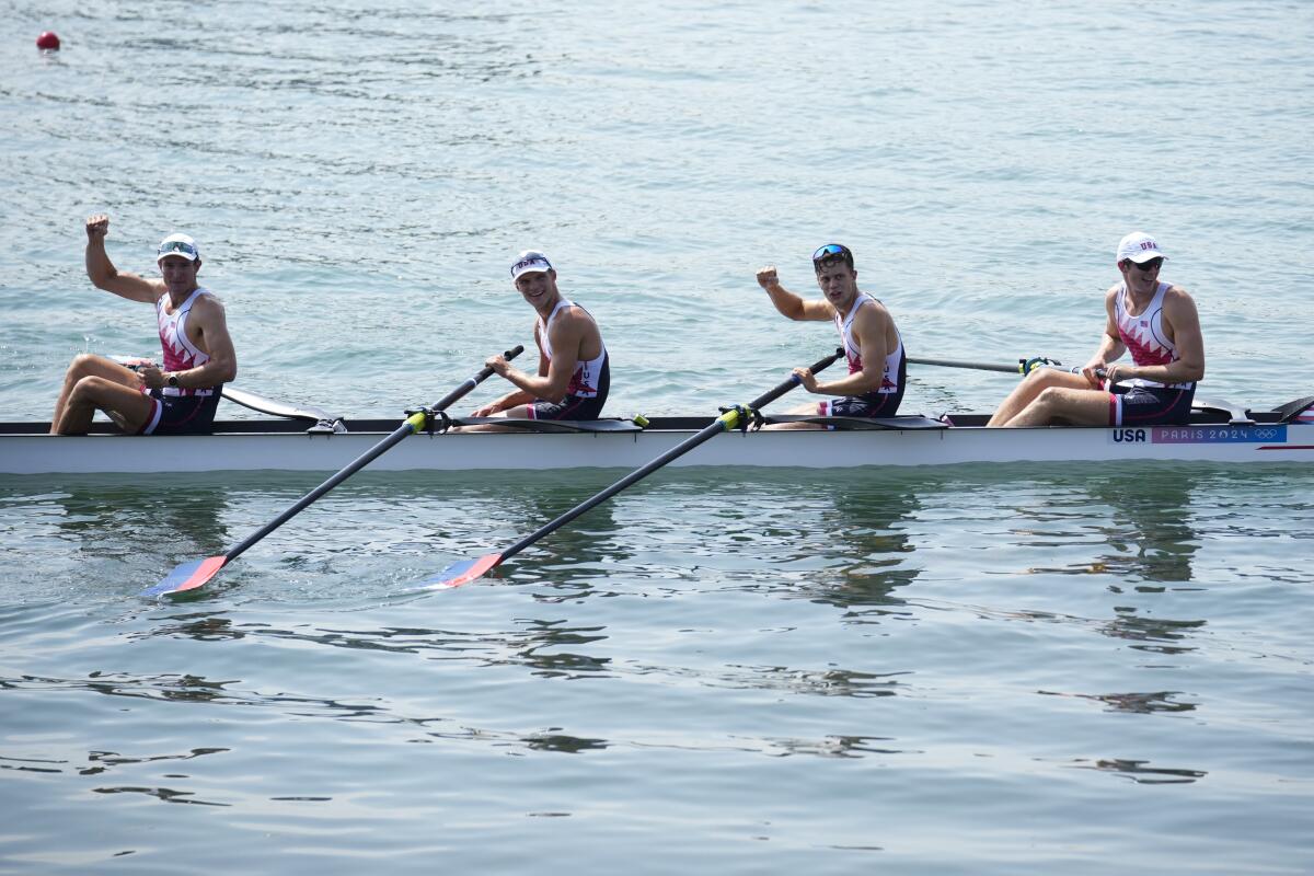 Four Americans celebrate their gold medal in men's rowing.