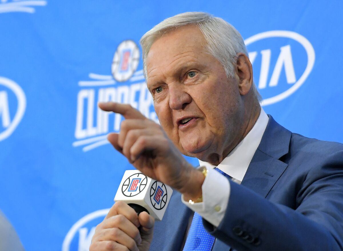 Jerry West points as he speaks during a news conference.