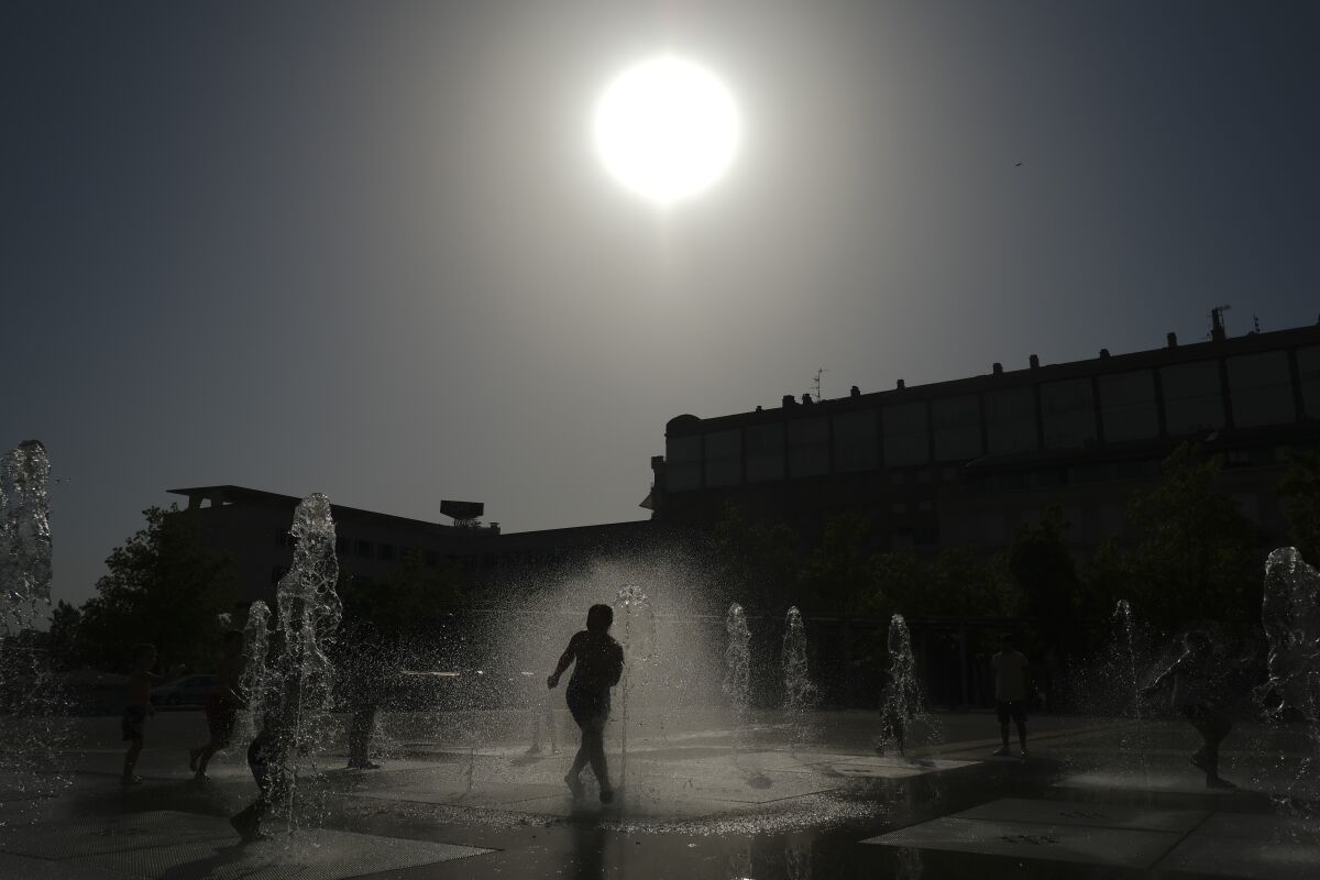 A child cools off with the water to the fountain during a heatwave in Pamplona, northern Spain, Friday Aug. 13, 2021. Stifling heat is gripping much of Spain and Southern Europe, and forecasters say worse is expected to come. (AP Photo/Alvaro Barrientos)