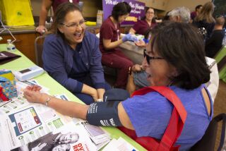 Teresa Bleifus RN,(CQ) with Temecula Valley Hospital laughs as she takes Ana Galarraga's(CQ) blood pressure during the annual Health and Community Resource Fair at the Temecula Civic Center Saturday, September 28, 2019.