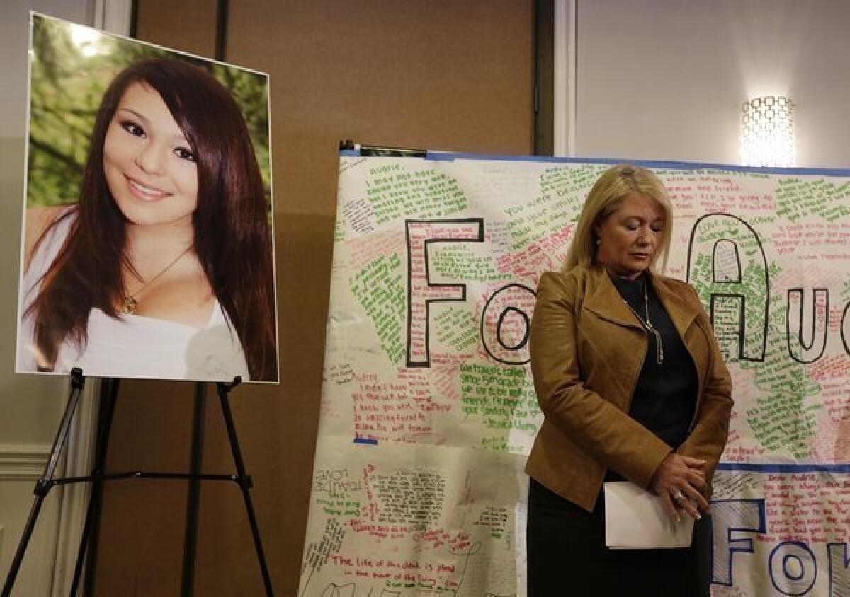 Sheila Pott, mother of Audrie Pott, who committed suicide after an alleged sexual assault, stands by a photograph of her daughter and message board during a news conference Monday.