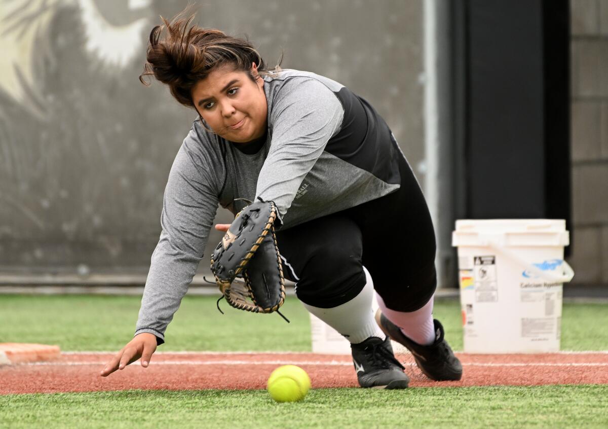 Anahi Arreola tries to make a diving, backhand catch on a grounder during a softball practice at Oaks Christian High.