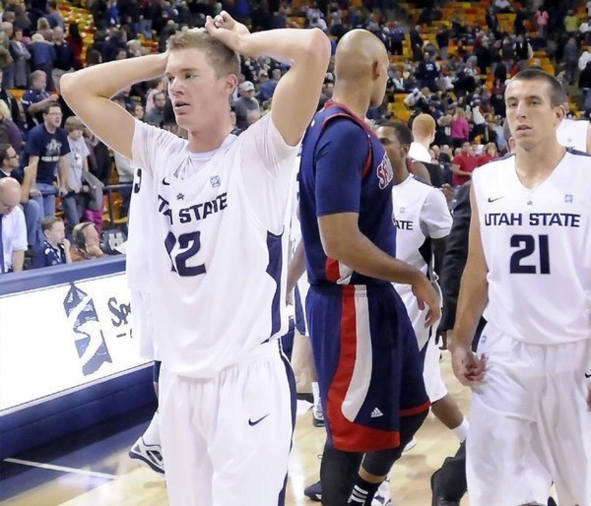 Utah State forward Danny Berger, left, walks off the court after a game against Saint Mary's.