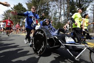 Rick Hoyt, center, is pushed by his father Dick, left, along the Boston Marathon course, April 15, 2013, in Wellesley, Mass.