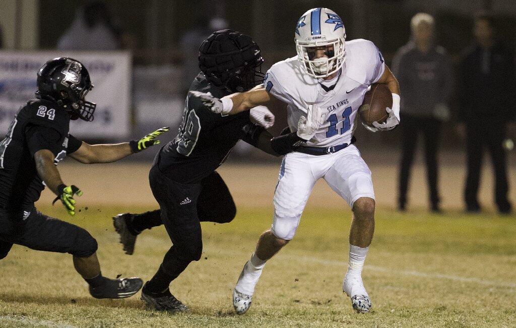 Corona del Mar High's Dylan Tucker gets wrapped up by a Buena Park defender on a punt return in the first half.
