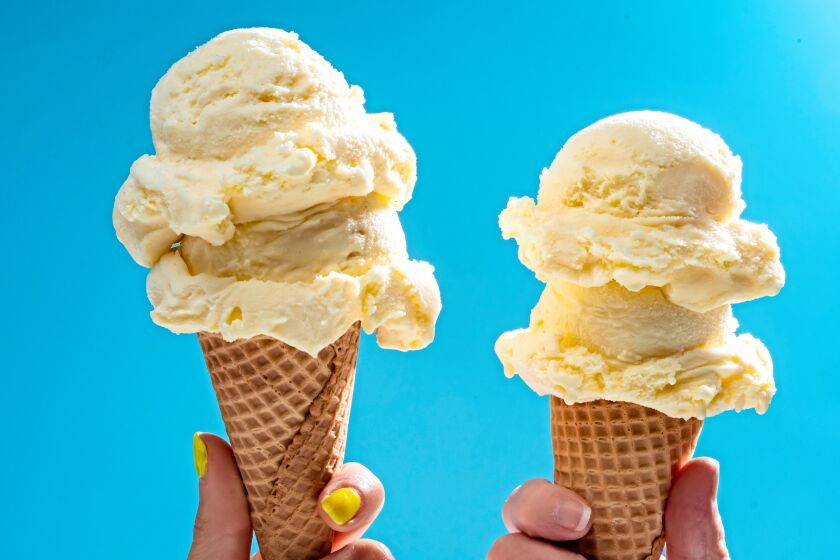 Two ice cream cones topped with double scoops of vanilla ice cream.