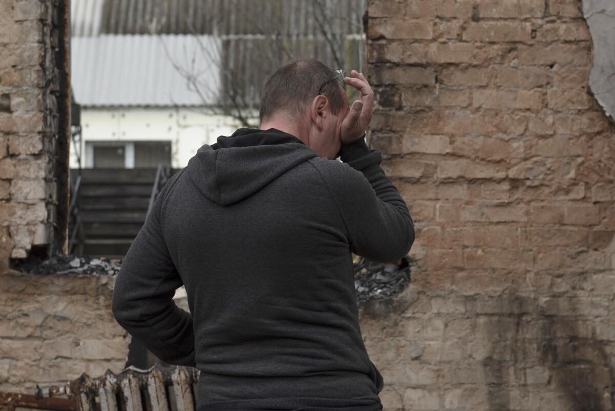 Vadym Zherdetsky reacts standing in the remains of his destroyed house, in the village of Moshun, outside Kyiv, Ukraine, Friday, Nov. 4, 2022. (AP Photo/Andrew Kravchenko)