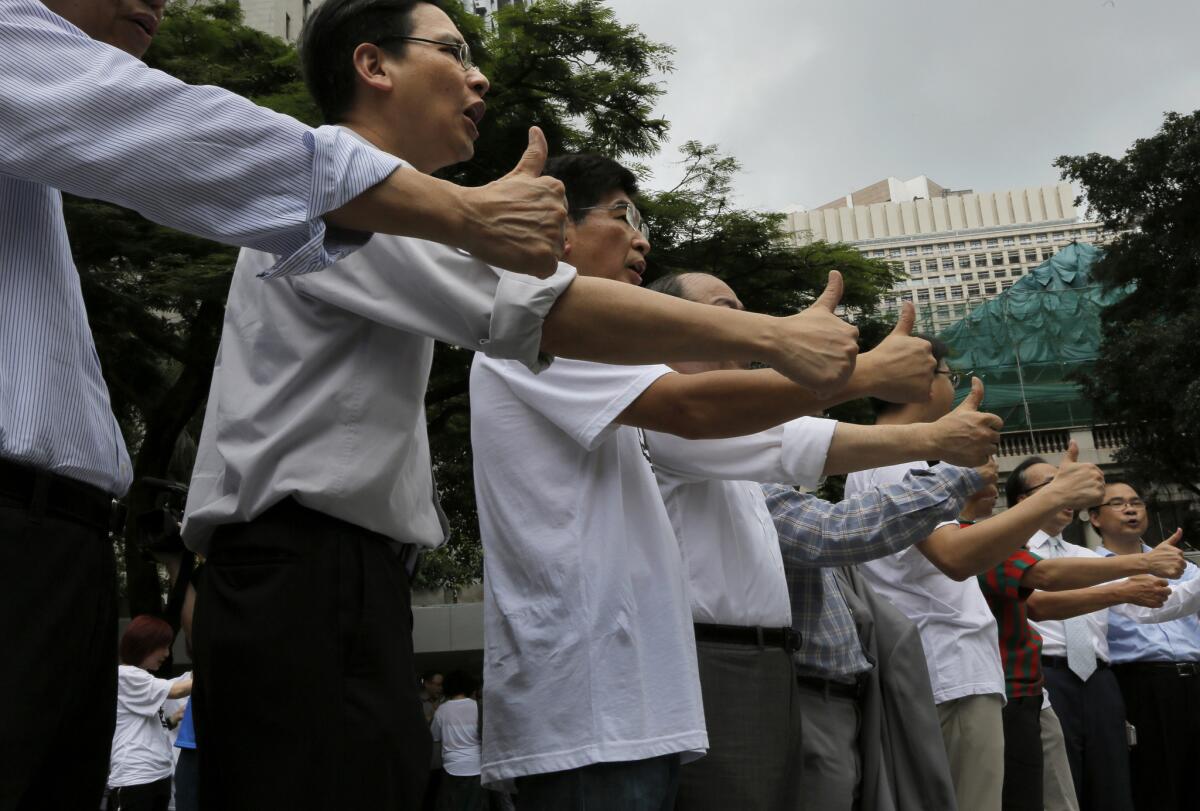 Pro-democracy supporters show thumbs-up signs during a kickoff ceremony Friday of a referendum on democracy in Hong Kong.