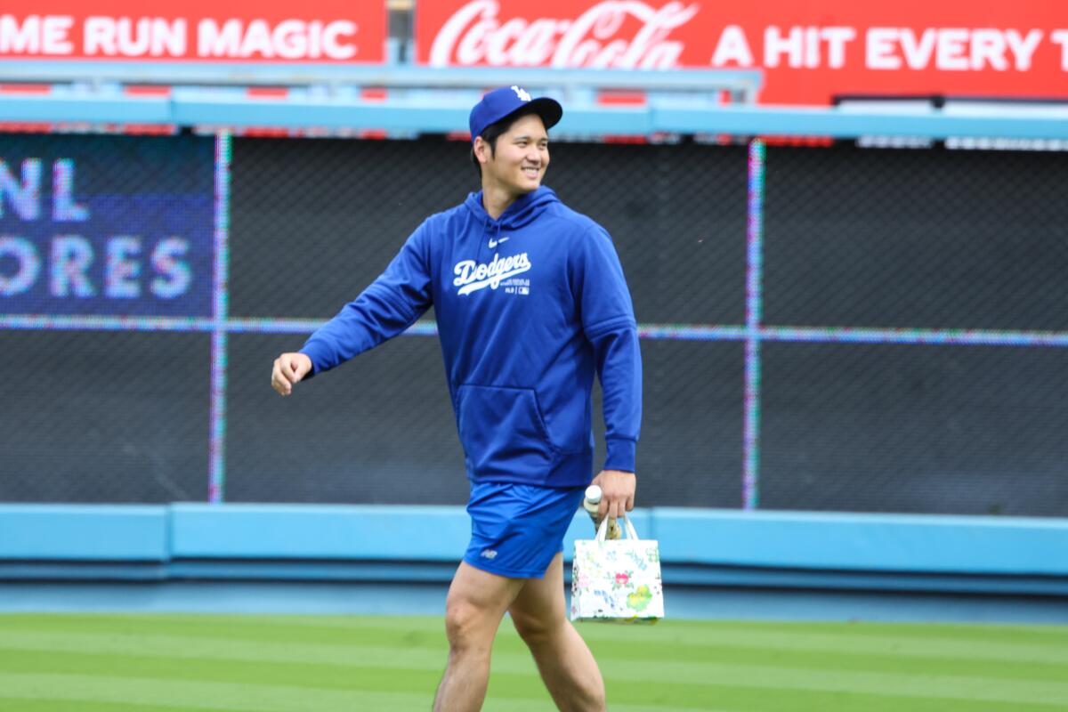 Dodgers star Shohei Ohtani walks on the field at Dodger Stadium after greeting former Angels teammates.