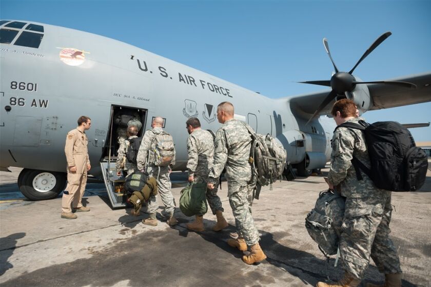 U.S. service members taking part in the humanitarian mission fighting the Ebola outbreak in West Africa board an Air Force C-130 Hercules transport in Dakar, Senegal.