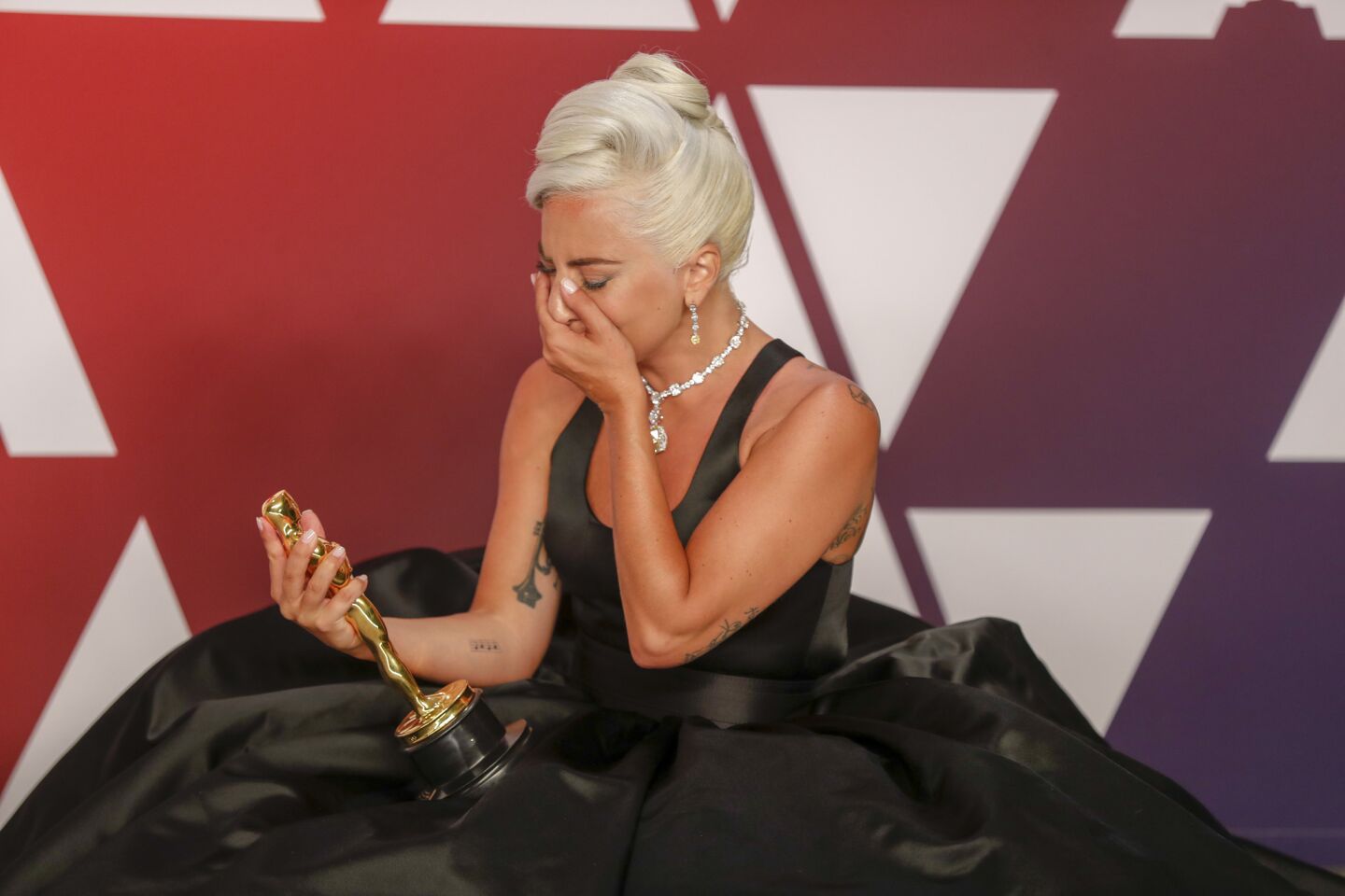 An emotional Lady Gaga poses with the original song Oscar for "Shallow."