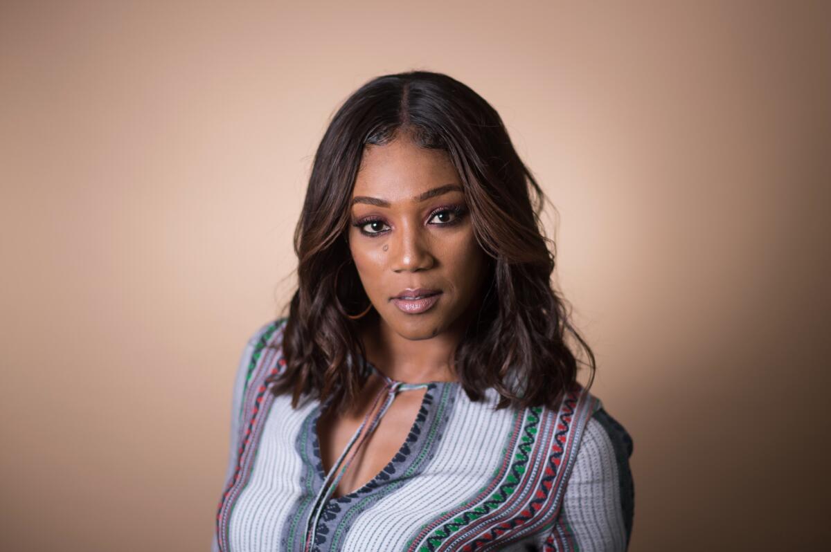 Tiffany Haddish from the shoulders up, in a striped shirt looking forward.