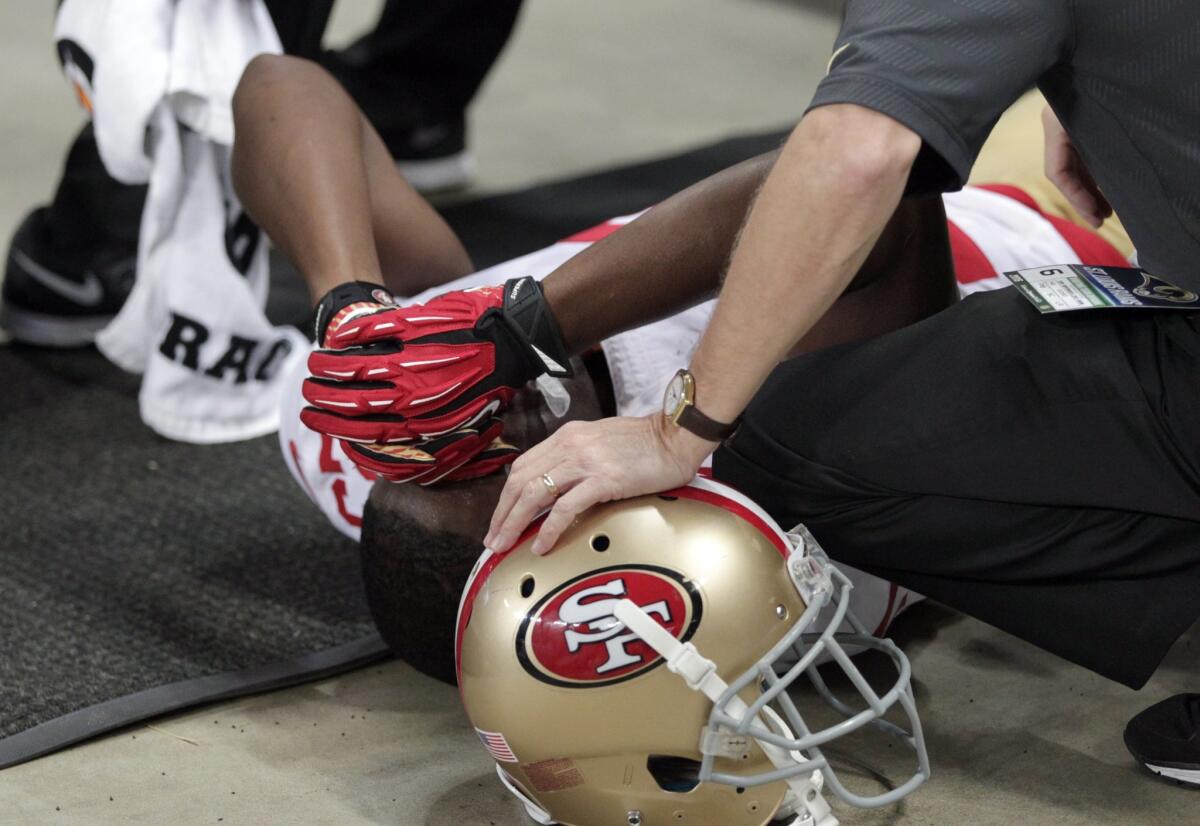 San Francisco running back Reggie Bush is tended to by a trainer after he slipped out of bounds against the St. Louis Rams on Nov. 1.