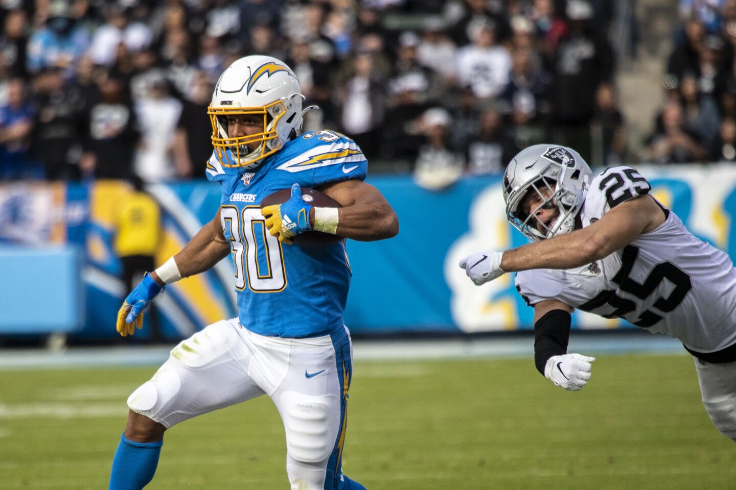Chargers running back Austin Ekeler spins away from Oakland Raiders free safety Erik Harris.