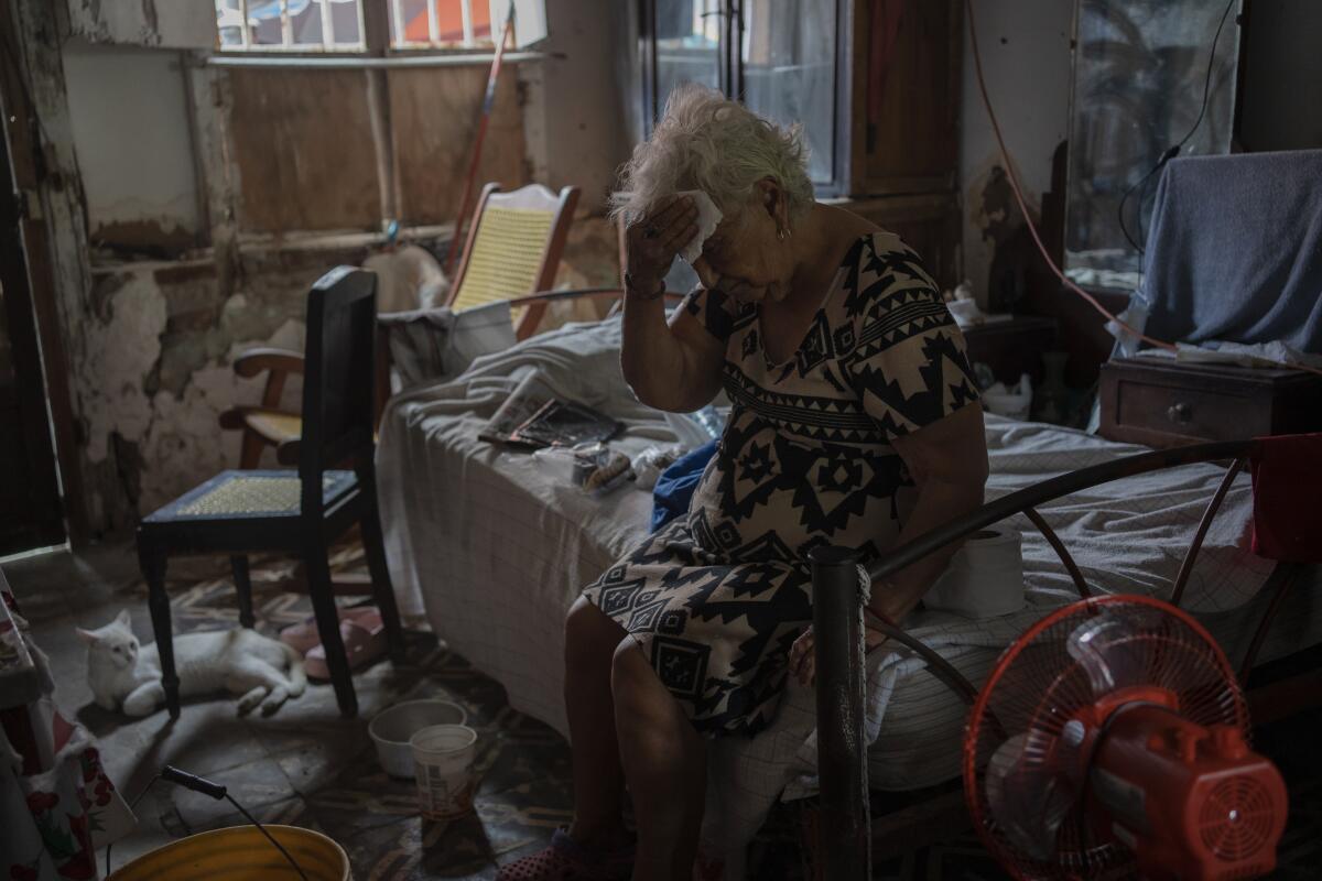 Margarita Salazar, 82, wipes the sweat off with a tissue inside her home amid high heat in Veracruz