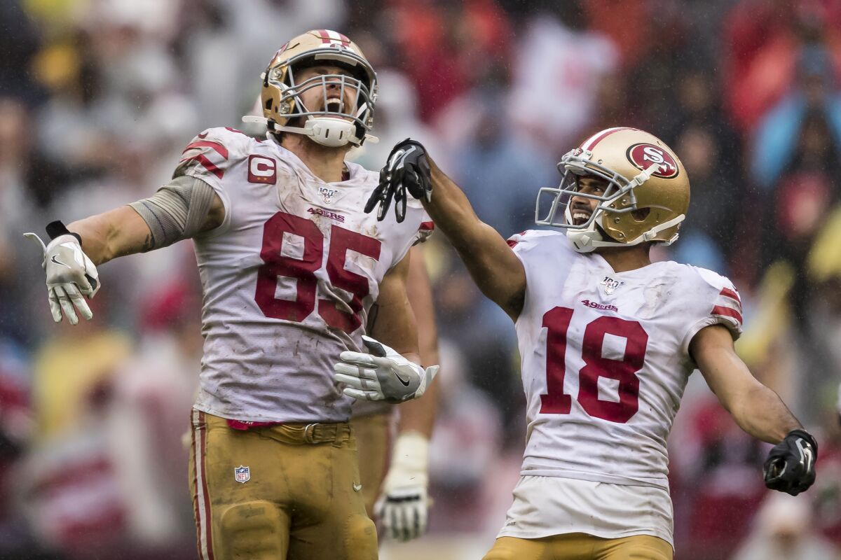 San Francisco 49ers teammates George Kittle, left, and Dante Pettis celebrate after a first down.