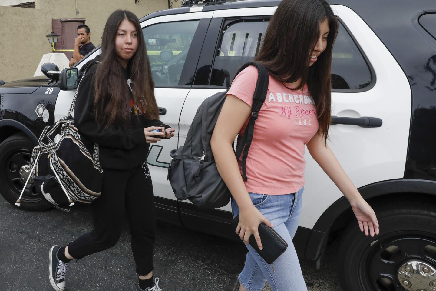 Twin sisters, reportedly the daughters of a woman who was stabbed at a business in Garden Grove on Wednesday, leave the Casa De Portola apartment complex.