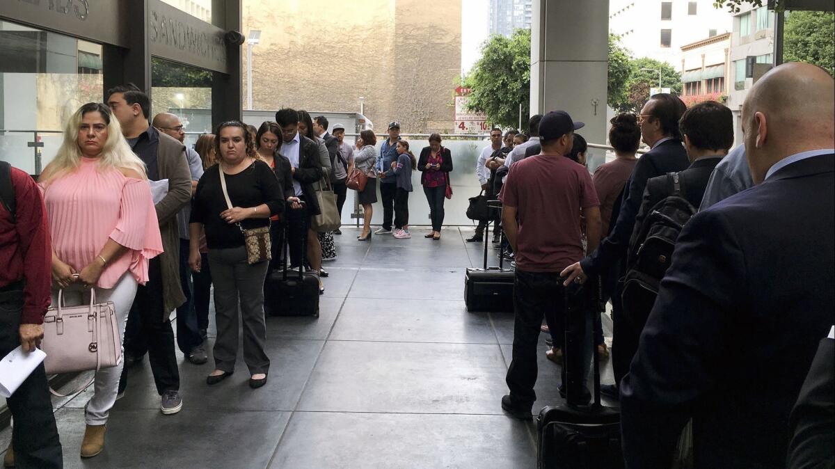 Immigrants awaiting deportation hearings line up outside the building that houses the immigration courts in Los Angeles on June 19.