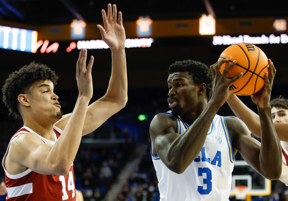 UCLA Bruins forward Adem Bona controls the ball under pressure from Stanford defenders.
