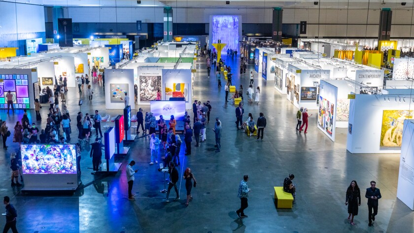 A large room full of booths displaying art.