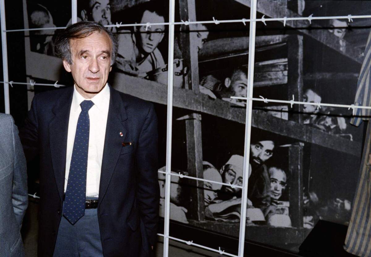 Nobel Peace Prize laureate and writer Elie Wiesel at the Yad Vashem Holocaust memorial in Jerusalem in 1986. The image behind shows him, bottom, third from right, and other inmates at the Nazis' Buchenwald concentration camp.