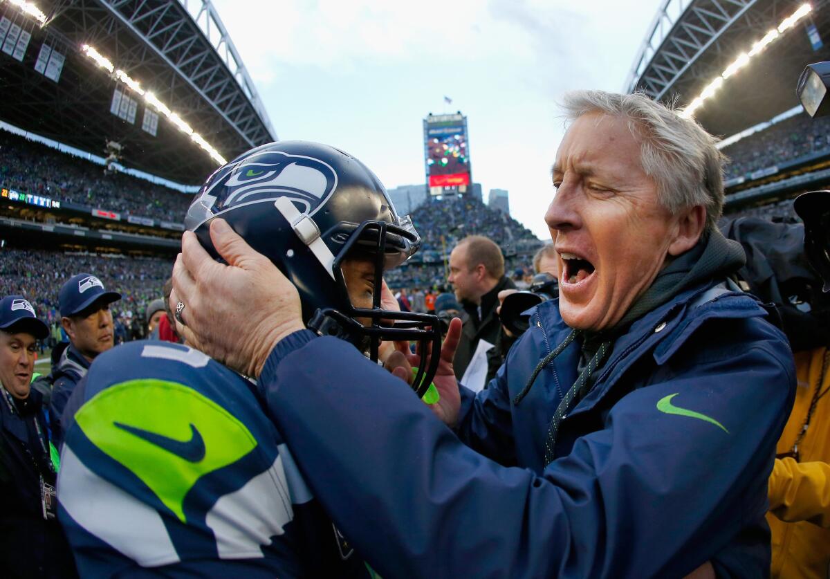 Seahawks Coach Pete Carroll celebrates with quarterback Russell Wilson after a 28-22 overtime defeat of the Green Bay Packers in the NFC championship game.