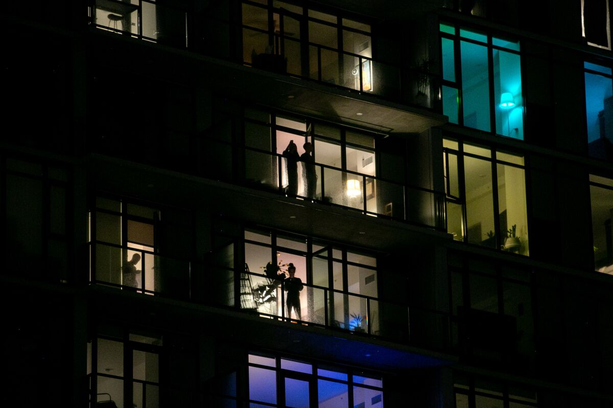 Residents cheer on healthcare workers from their balconies at the Alexan ALX apartments in the East Village neighborhood of downtown San Diego on April 6, 202,0 in San Diego.