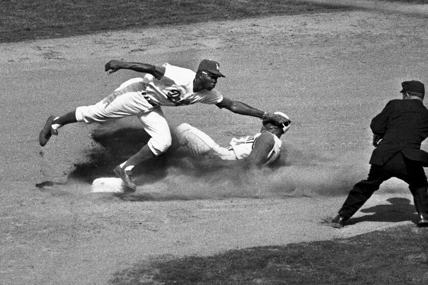April 10, 1962: Dodger second baseman Jim Gilliam makes a stop on Daryl Spencer's wide throw as Tommy Harper slides safely into second during the sixth inning.