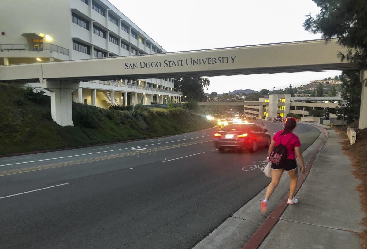 A woman walks near a bridge on the San Diego State University campus.