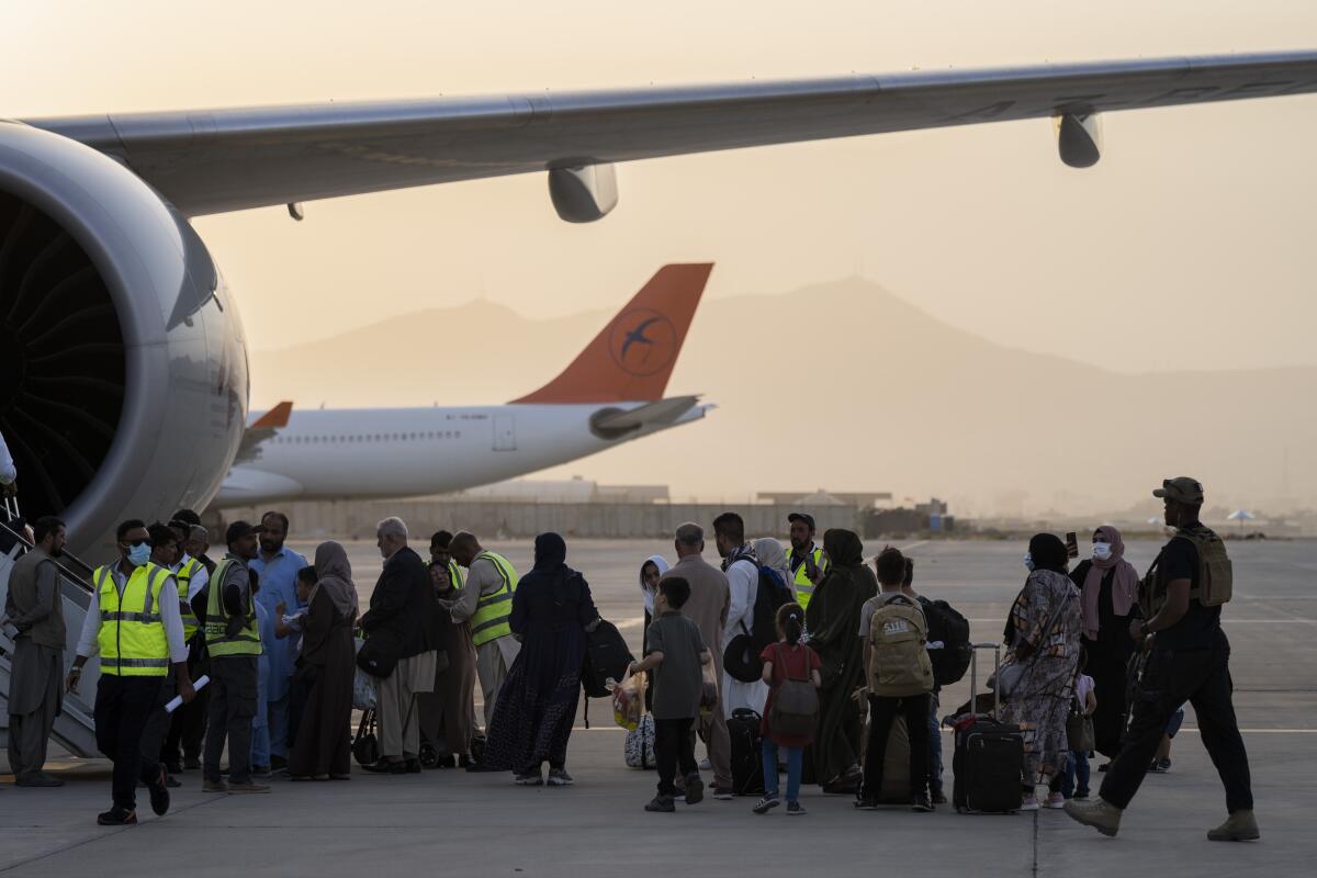 People board a Qatar Airways aircraft at the airport in Kabul