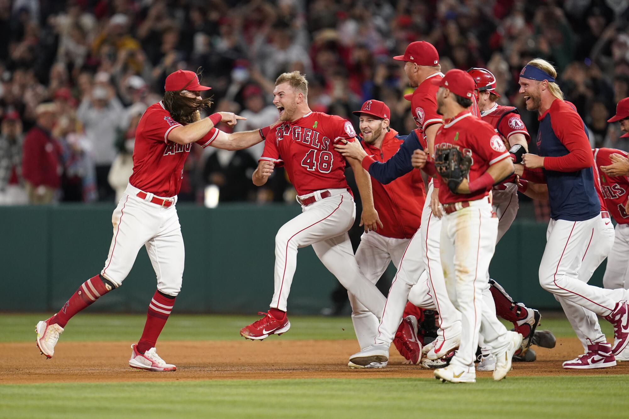 Reid Detmers (48) is swarmed by Angels teammates after completing a no-hitter against the Rays.
