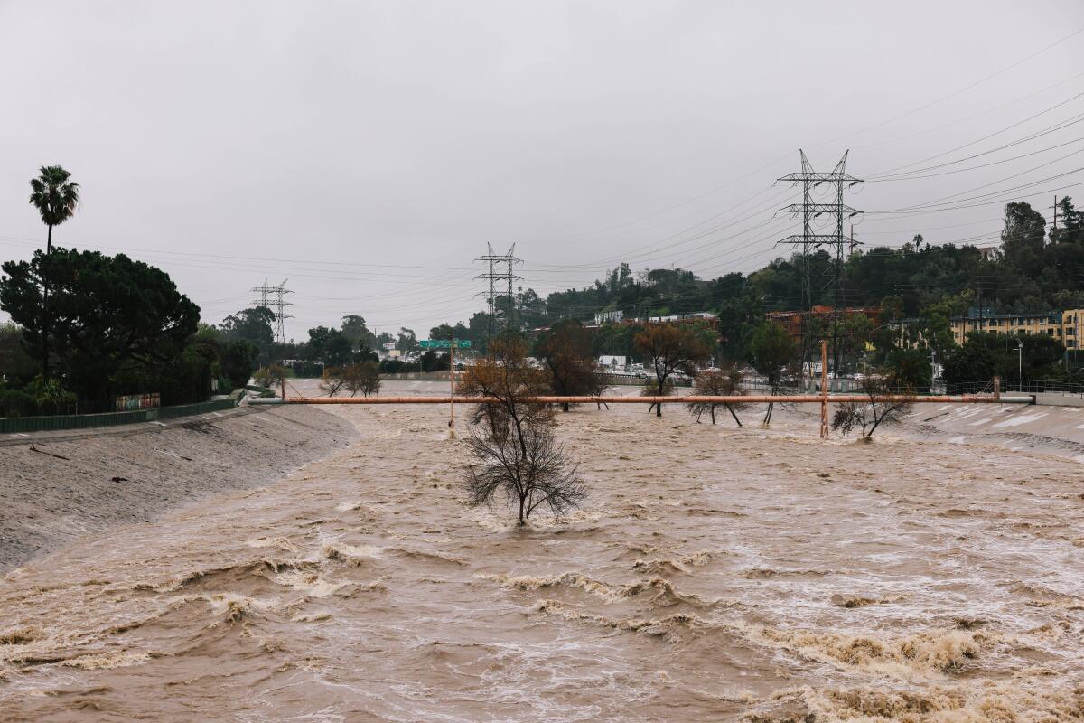Fast-moving storm runoff fills the Los Angeles River through Atwater Village on Monday.