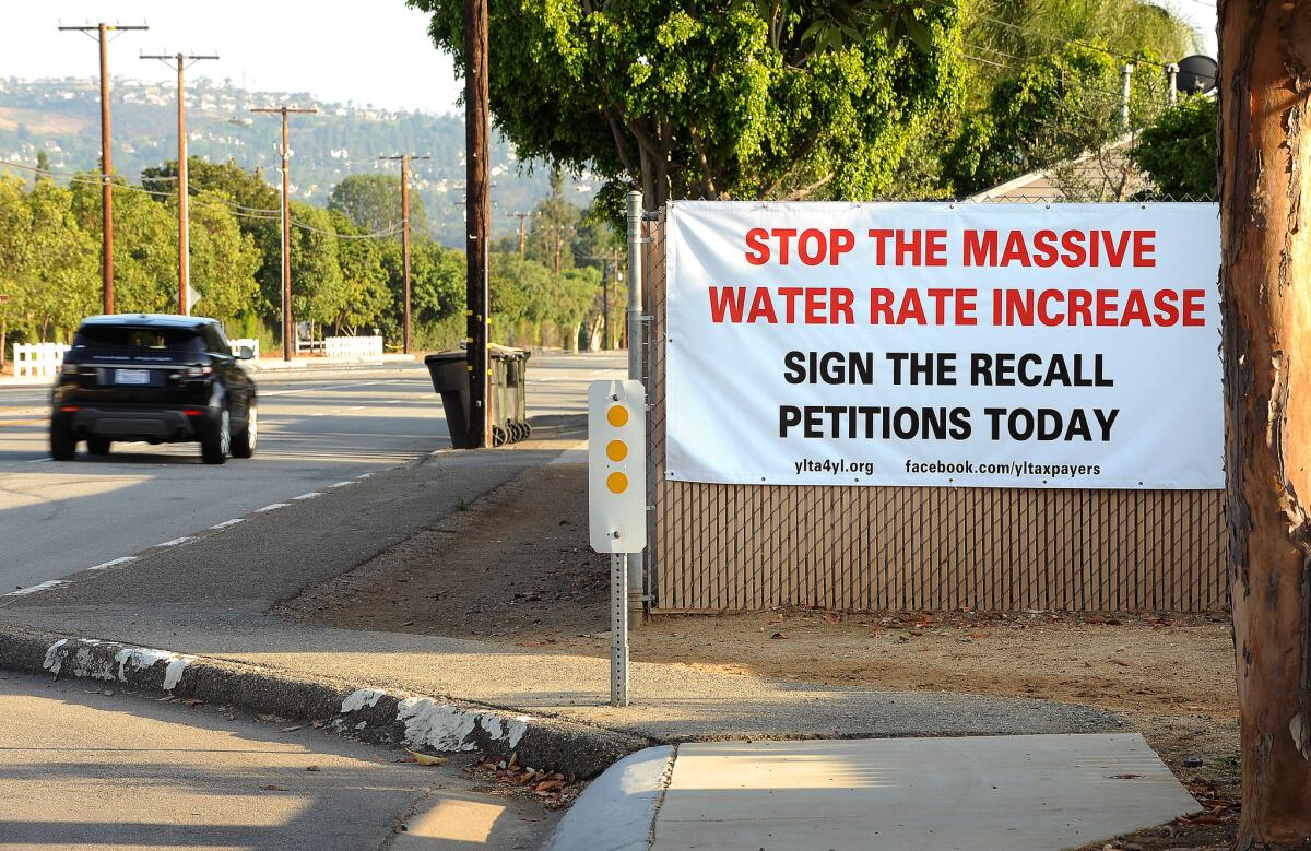 A sign calling for Yorba Linda residents to sign a petition to stop water rate increases is posted on a fence in Yorba Linda.