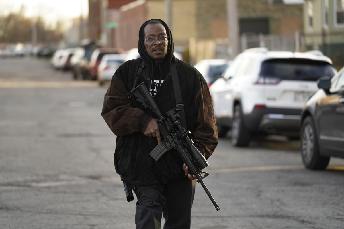 Erick Jordan camina por la calle con su fusil para ofrecer protección