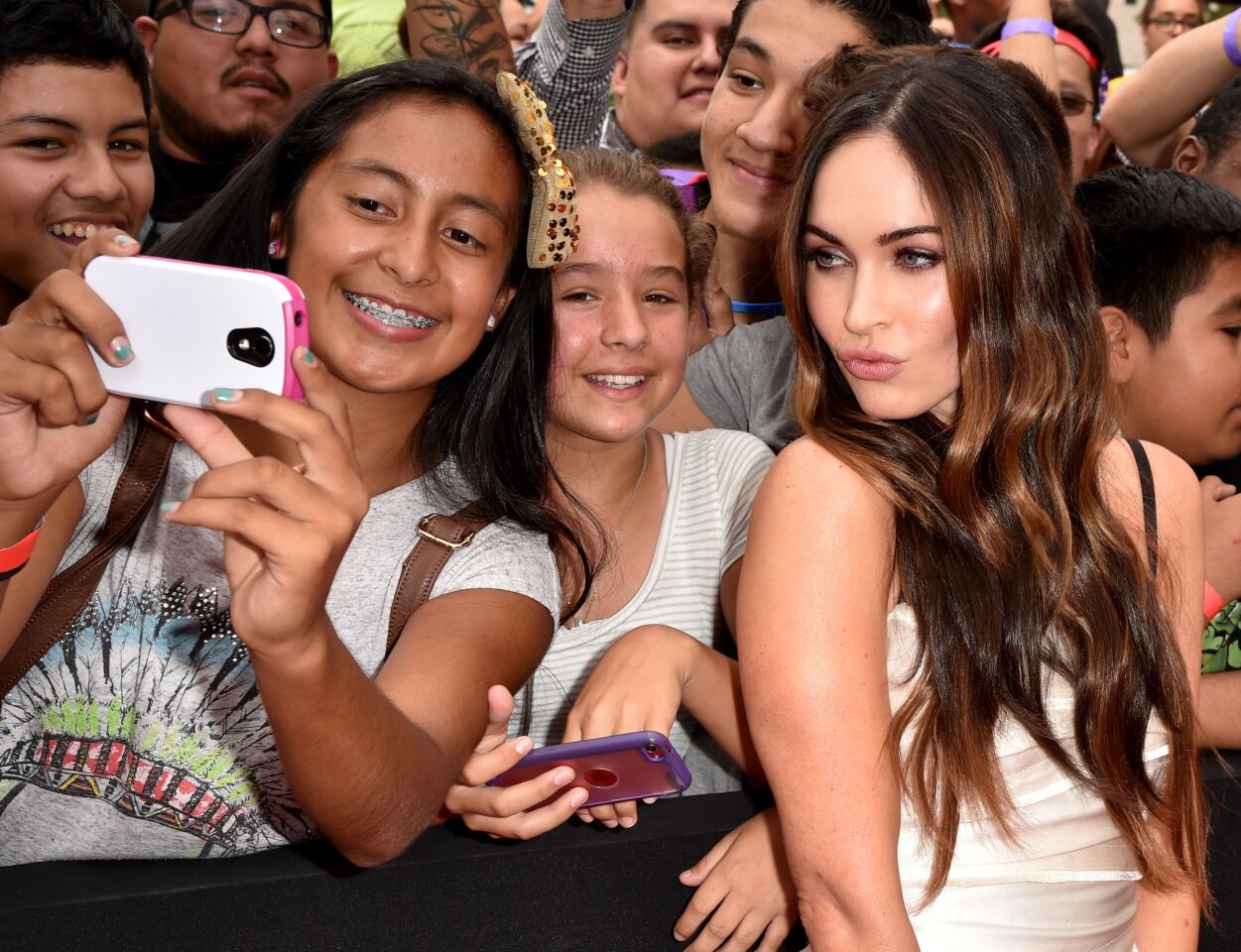 Actress Megan Fox, right, joins a selfie with fans at the premiere of Paramount Pictures' "Teenage Mutant Ninja Turtles" at Regency Village Theater in Westwood on Aug. 3