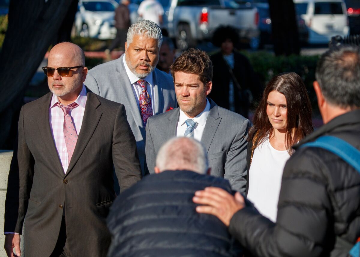 Newport Beach surgeon Grant Robicheaux, center, and his girlfriend, Cerissa Riley, arrive at Orange County Superior Court's Harbor Justice Center in Newport Beach on Friday for a hearing on possible dismissal of sexual assault charges against them.