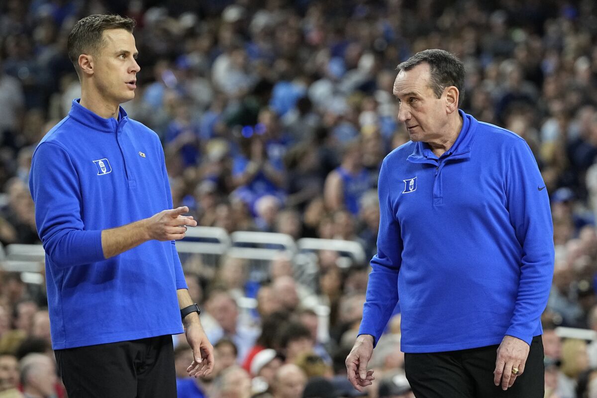 Duke assistant coach Jon Scheyer and head coach Mike Krzyzewski work during the first half of a college basketball game in the semifinal round of the Men's Final Four NCAA tournament, Saturday, April 2, 2022, in New Orleans. (AP Photo/David J. Phillip)