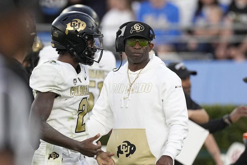 Colorado head coach Deion Sanders, right, looks at his son quarterback Shedeur Sanders during the first half of an NCAA college football game against UCLA Saturday, Oct. 28, 2023, in Pasadena, Calif. (AP Photo/Mark J. Terrill)