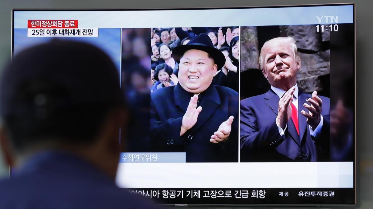 A man watches a TV screen showing file footage of U.S. President Donald Trump, right, and North Korean leader Kim Jong Un, in Seoul, South Korea.