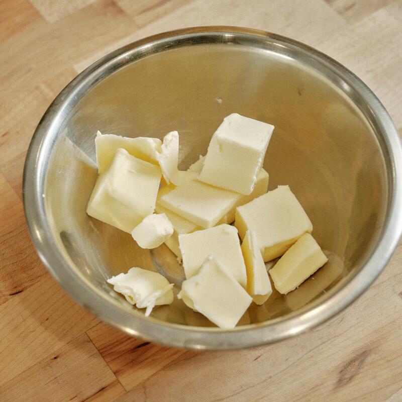 Sticks of butter cut into smaller pieces, in a metal bowl