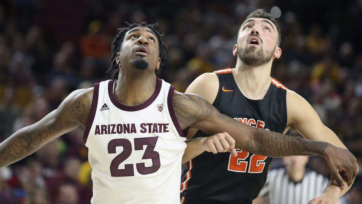 Arizona State and Princeton players battle for position under the basket during the first half of an NCAA college basketball game on Dec. 29, 2018, in Tempe, Ariz.