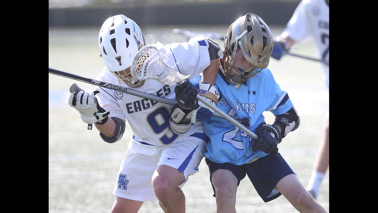 Corona del Mar's Aidan Kelly, right, gets an elbow from Santa Margarita's Matt Ury, as they battle for the ball in the quarterfinals of the U.S. Lacrosse Southern Section South Division playoffs on Thursday.